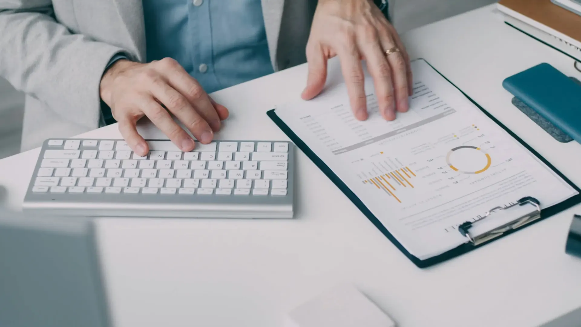Ejecutivo revisando estados financieros y gráficas de cuotas obrero-patronales en un escritorio: dictamen IMSS de Rodríguez Bravo y Asociados para empresas de 300 empleados o más.